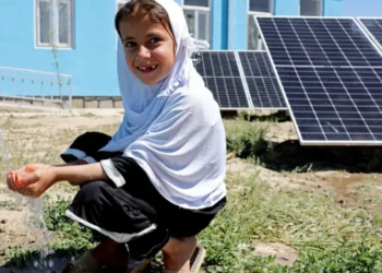 A young girl collects water from a solar-powered water system in Afghanistan (Photo: UNDP)