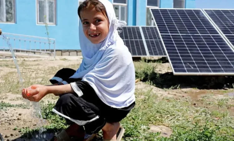 A young girl collects water from a solar-powered water system in Afghanistan (Photo: UNDP)