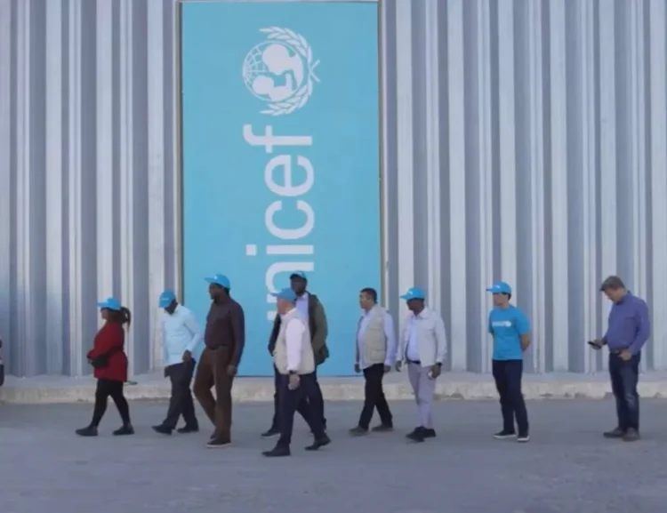 UNICEF staff and representatives walk outside a facility displaying the organization's logo (Photo: UNICEFAfg)