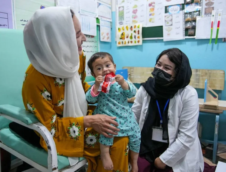 An Afghan mother holds her child during a visit to a health facility (Photo: UNICEF)