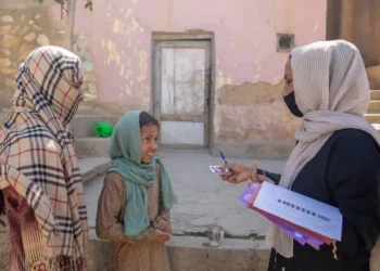 A UNICEF female employee provides support to a child and her mother as part of nutritional assistance in Afghanistan. (Photo credit: UNICEF)