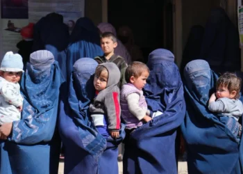 Afghan women in burqas with their children standing (Photo: WHO)