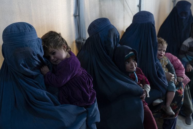 This photograph taken on January 9, 2024 shows Afghan burqa-clad women and children refugees deported from Pakistan, in a nutrition ward at the United Nations High Commissioner for Refugees (UNHCR) camp on the outskirts of Kabul. Millions face months of hunger and cold, with natural disasters and displacement putting more Afghans at risk even as funding to one of the world's poorest countries -- wracked by decades of war -- has plummeted. (Photo by Wakil KOHSAR / AFP) / TO GO WITH 'AFGHANISTAN-POVERTY-AID FOCUS BY PASCALE TROUILLAUD AND ABDULLAH HASRAT - To go with 'AFGHANISTAN-POVERTY-AID FOCUS by Pascale Trouillaud and Abdullah Hasrat